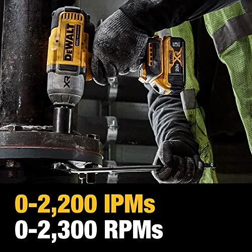 Person using DEWALT impact wrench on industrial equipment.